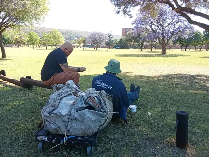 Volunteer sitting with a homeless man in Die Moot park