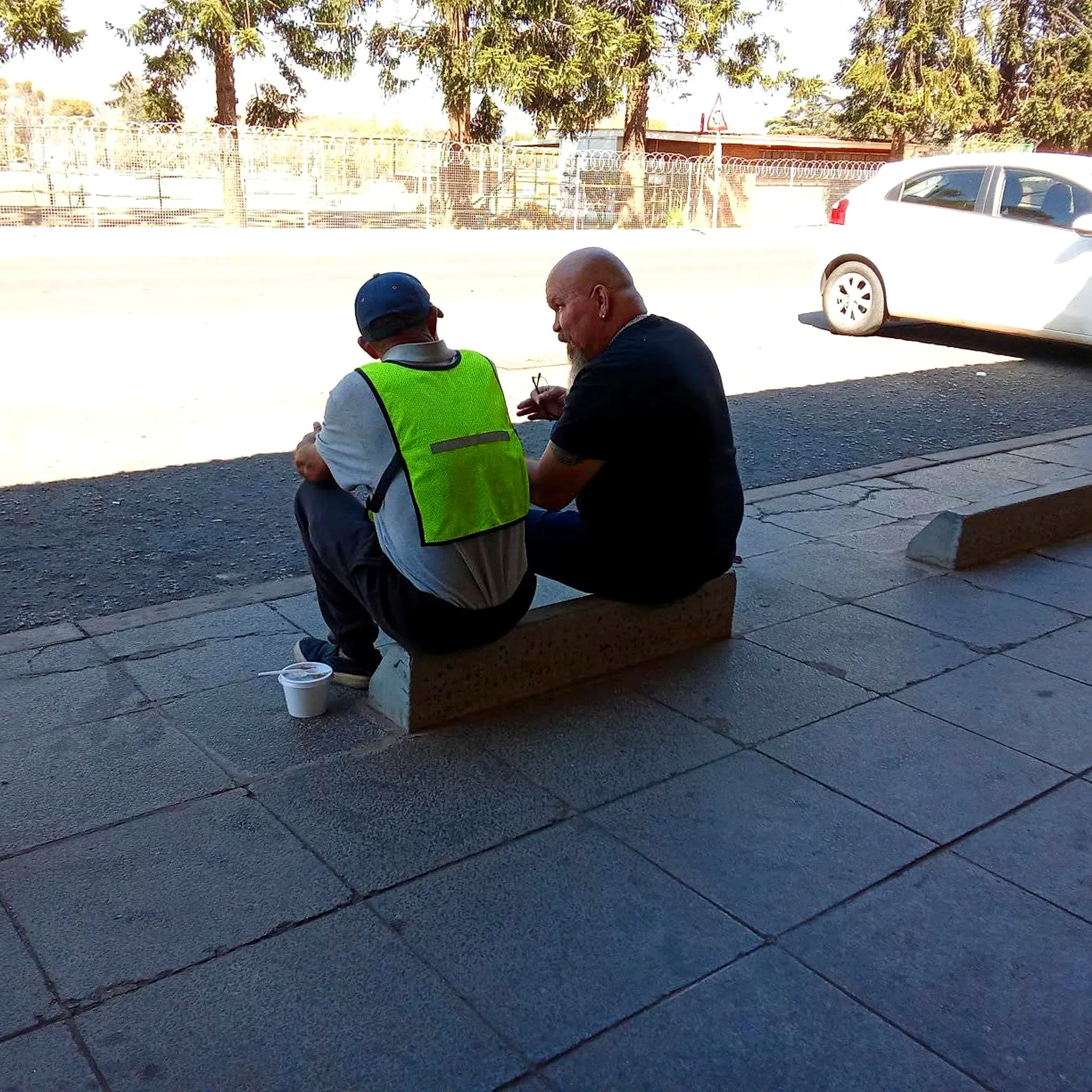 Volunteer sitting and talking with a homeless man on a Die Moot street